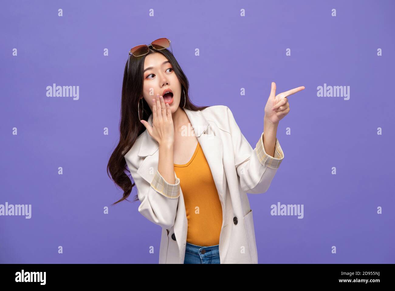 Waist up Porträt von geschockt ziemlich asiatische Frau zeigt Hände Um Platz beiseite auf isolierten lila Studio Hintergrund zu leeren Stockfoto