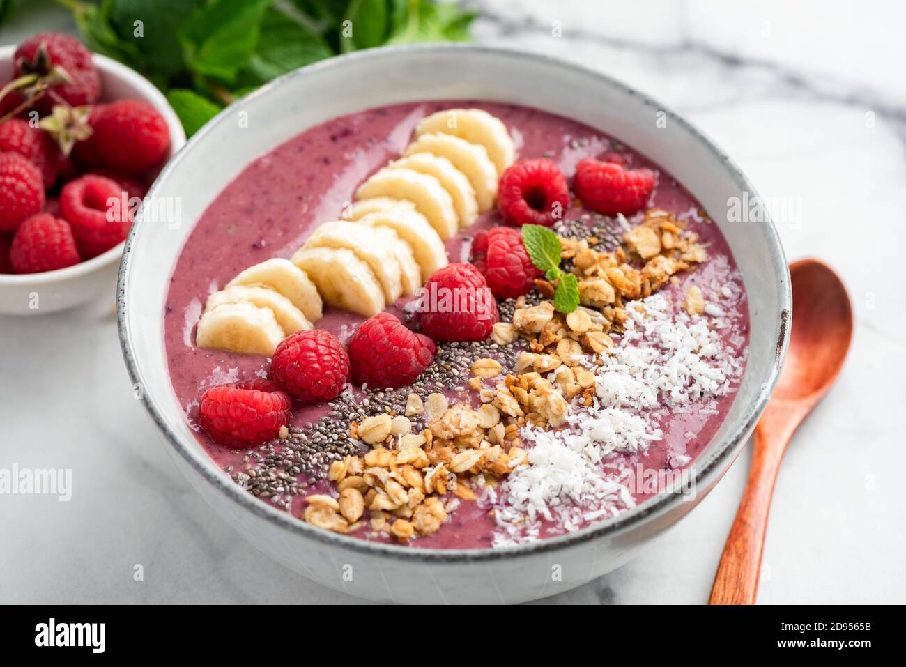 Vegane Detox Smoothie Schüssel mit Himbeere und Banane gekrönt mit Samen und Müsli Stockfoto