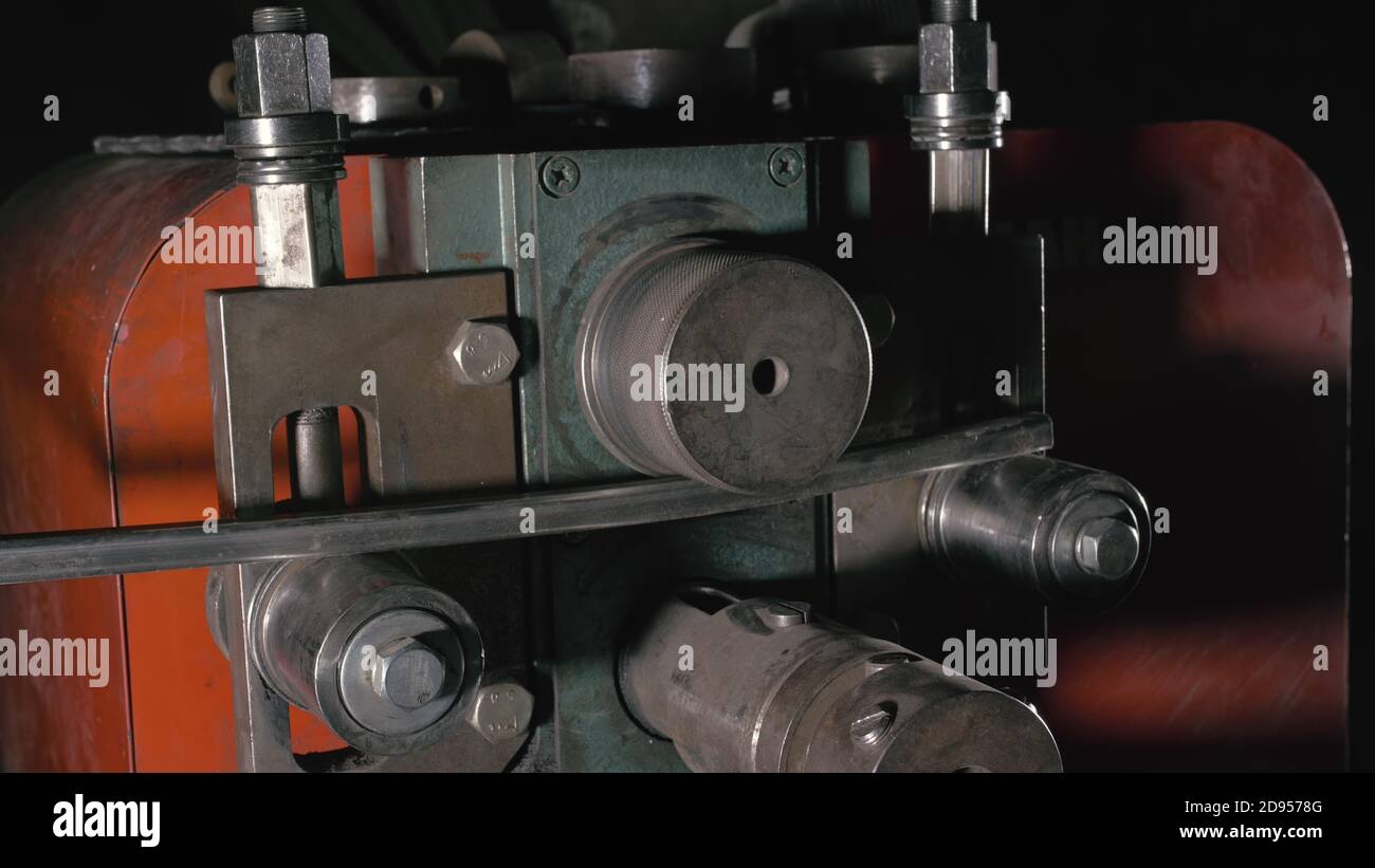 Schmiedewerkstatt auf dem Tisch. Arbeitnehmer Biegungen die Metallstange auf das schmiedeeiserne runde Biegemaschine. Herstellung von einem Designer Teil aus einer Metallstange. Stockfoto