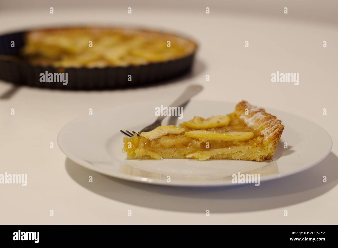 Teller mit Stück leckeren hausgemachten Apfelkuchen auf weiß Tabelle Stockfoto