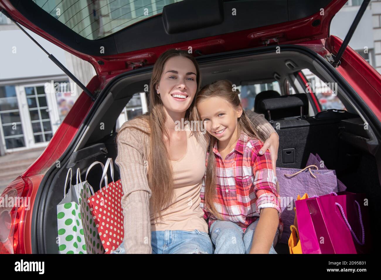 Glückliche Mutter und Tochter umarmt, sitzen im Auto Boot Stockfoto