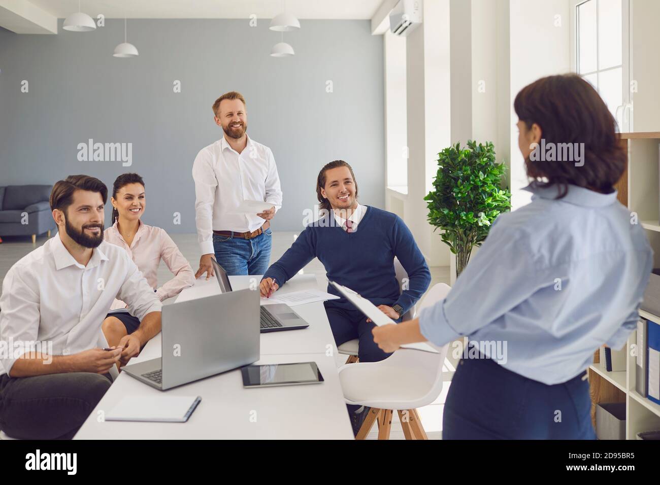 Frau, die Bericht für ein Team positiver Unternehmenskollegen in macht Firmenmeeting Stockfoto