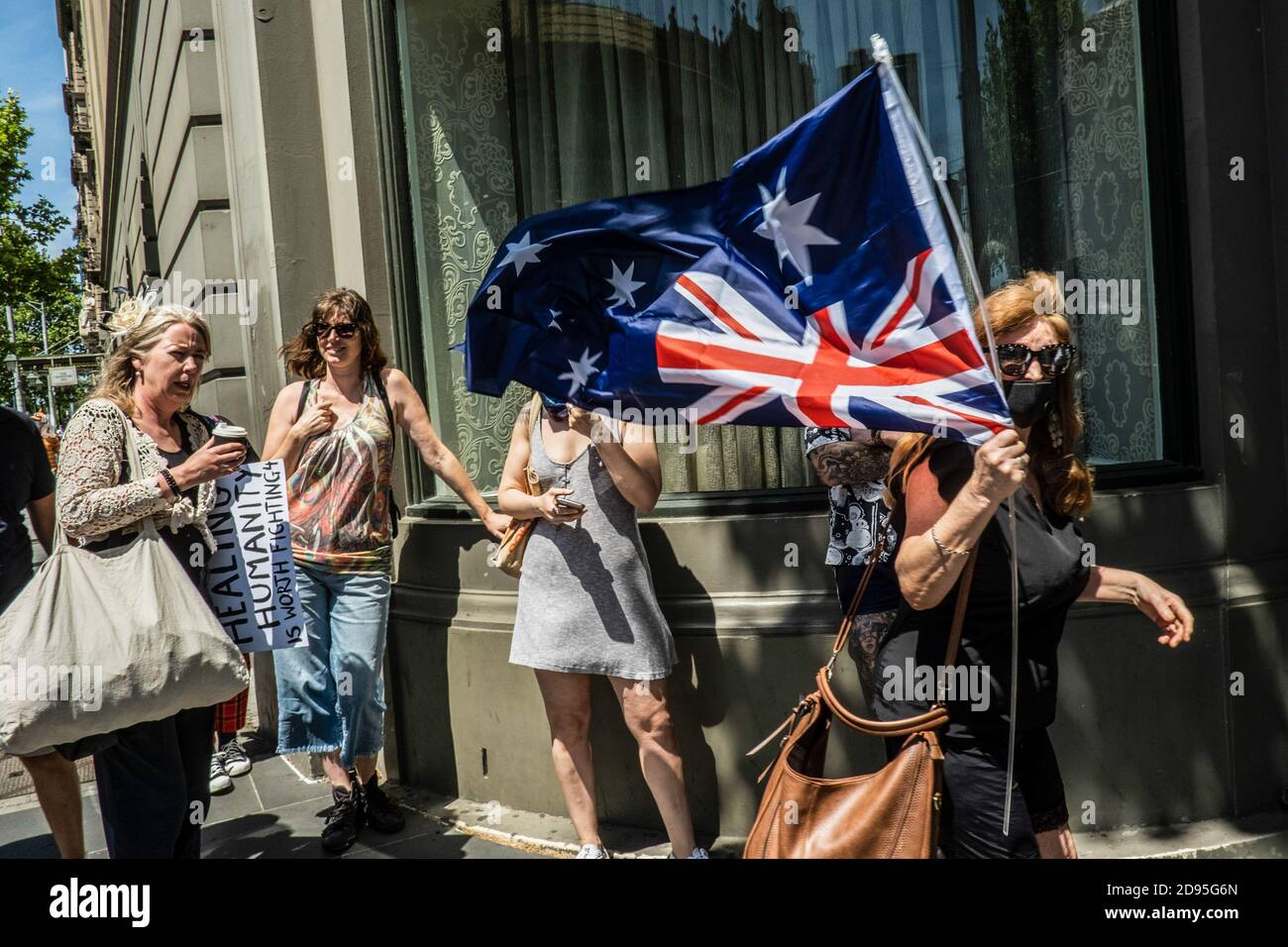 Melbourne, Australien. November 2020. Ein Protestler hält während der Demonstration eine australische Flagge auf dem Kopf. Bei einem Anti-Lockdown-Protest brach in Melbourne Gewalt aus, obwohl die Stadt ihre erste Woche der Freiheit von harten Restriktionen seit der Einführung der vierten Sperre genießt. Kredit: SOPA Images Limited/Alamy Live Nachrichten Stockfoto