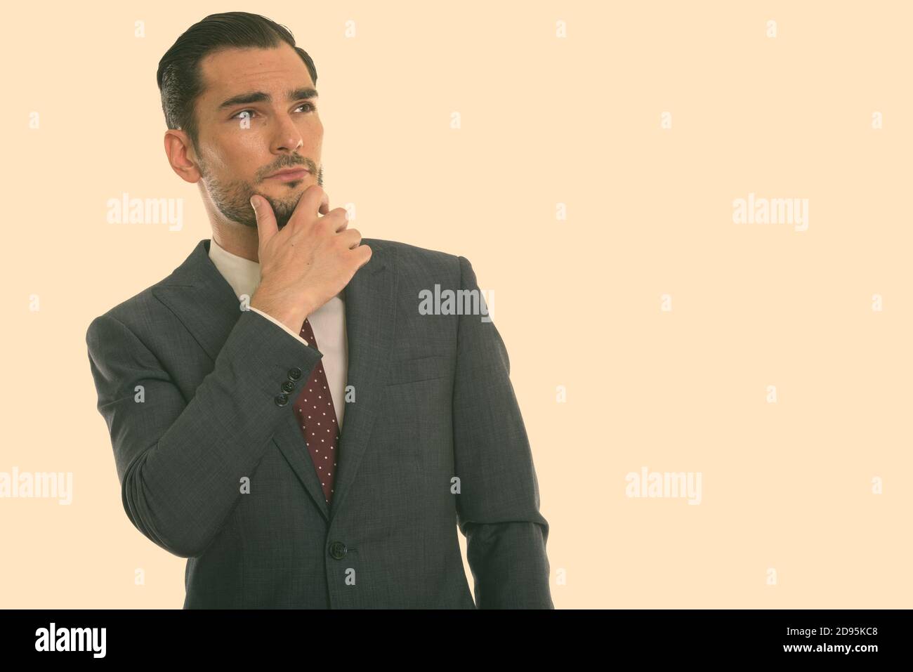 Studio shot von jungen hübschen Geschäftsmann Denken mit der Hand am Kinn Stockfoto