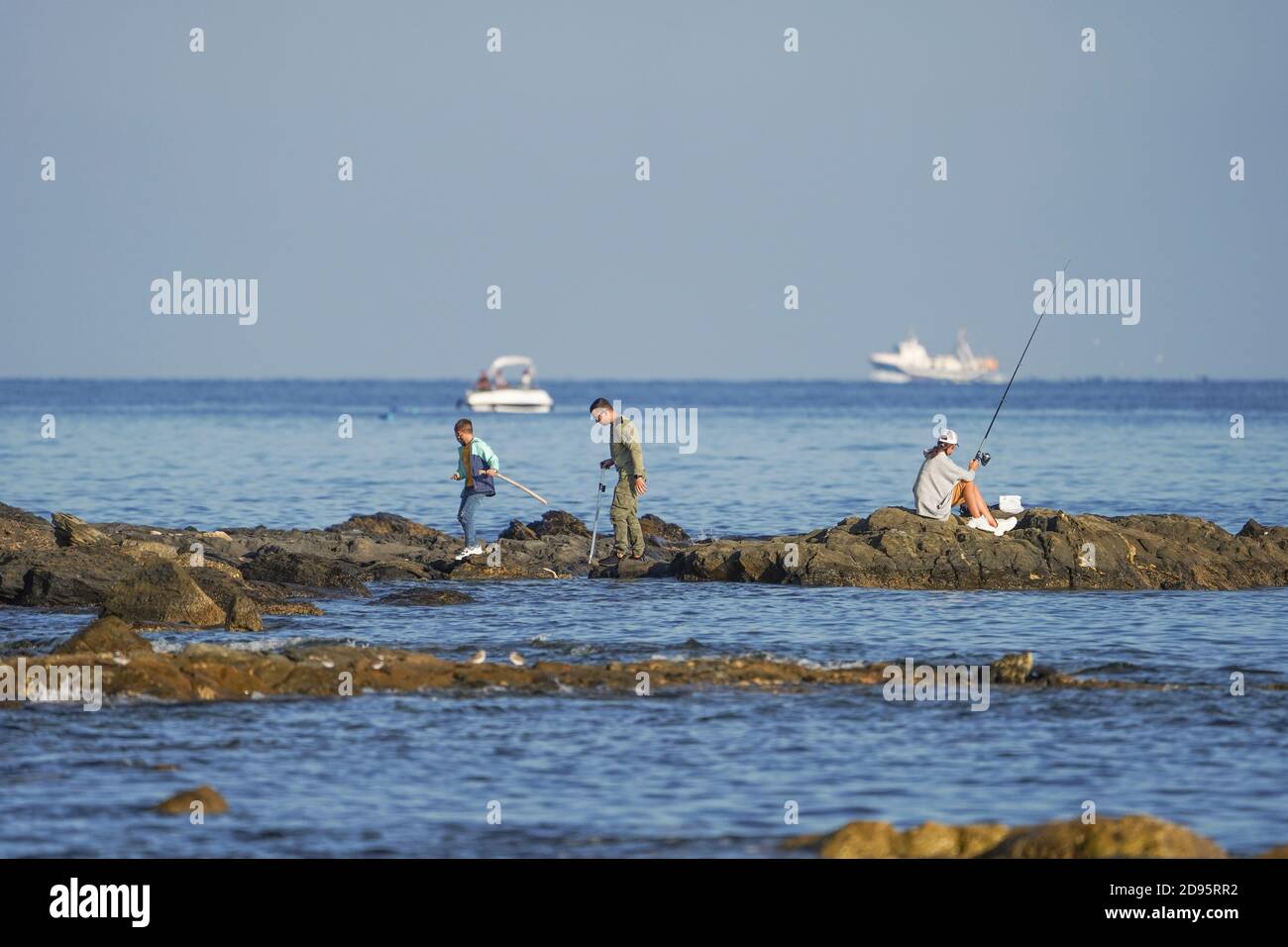 Familie von drei an der felsigen Küste Angeln, mittelmeer, La Cala, Spanien. Stockfoto