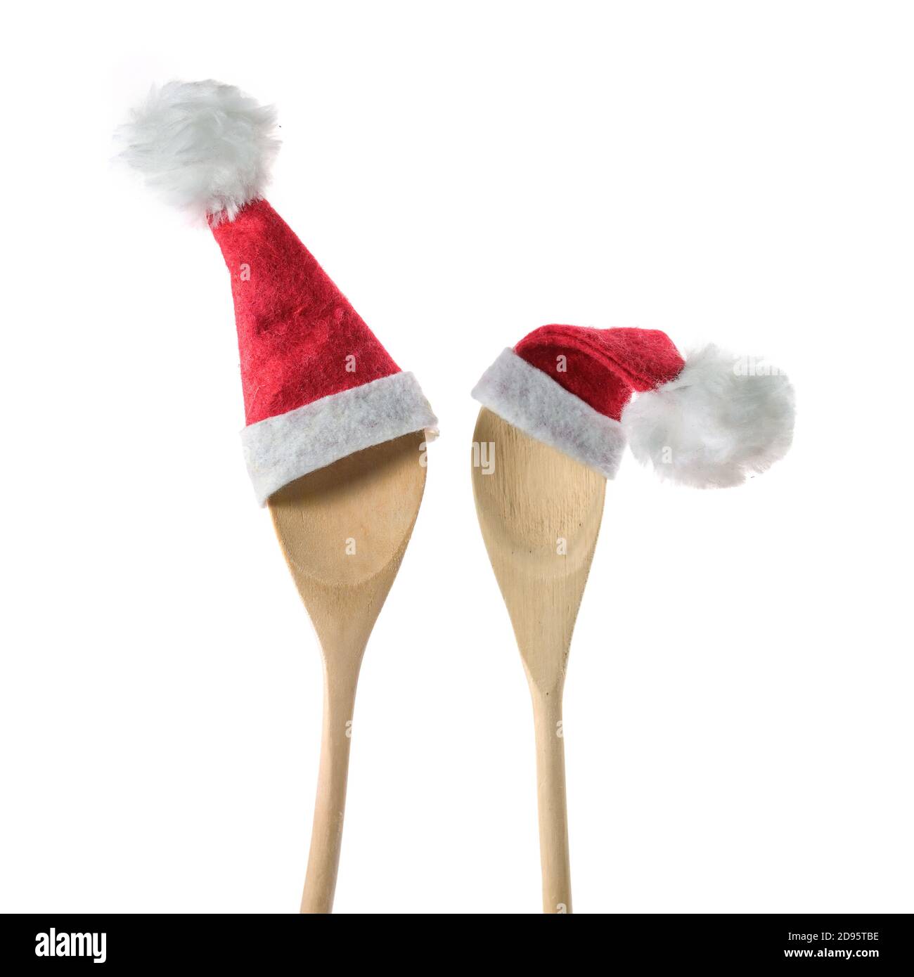 Zwei hölzerne Kochlöffel mit roten Weihnachtsmann Hüten isoliert auf weißem Hintergrund, Weihnachtsessen Einladung Konzept, Copy-Raum, ausgewählte Fokus Stockfoto