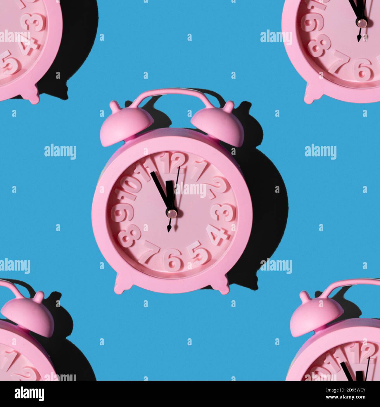 Modisches Muster mit einer rosa Uhr auf blauem Hintergrund, wiederholende Tapete mit einem minimalistischen nahtlosen Layout Stockfoto