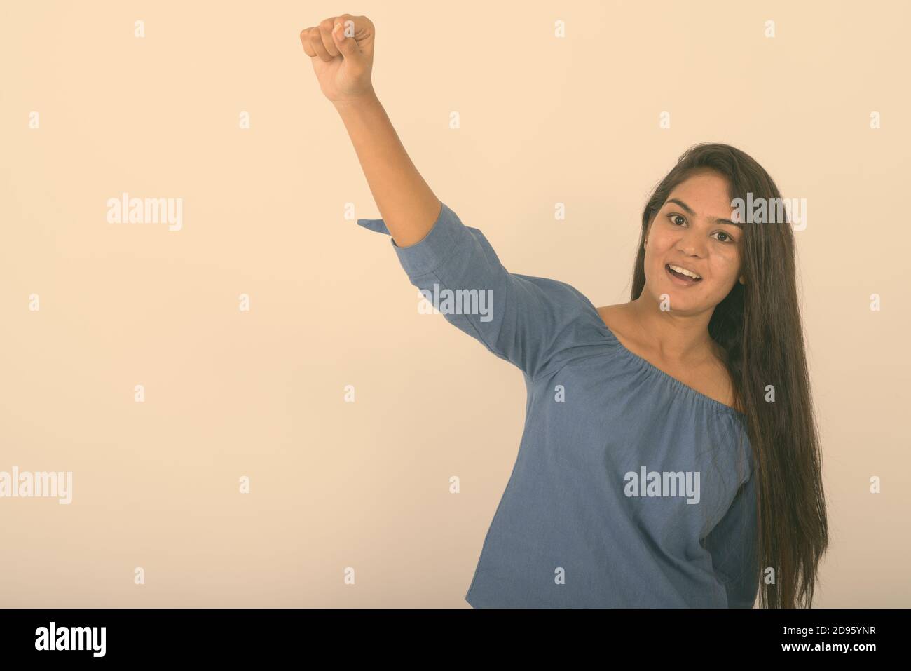 Studio shot der jungen indischen Glücklich lächelnde Frau, während sie gegen den weißen Hintergrund motiviert Stockfoto