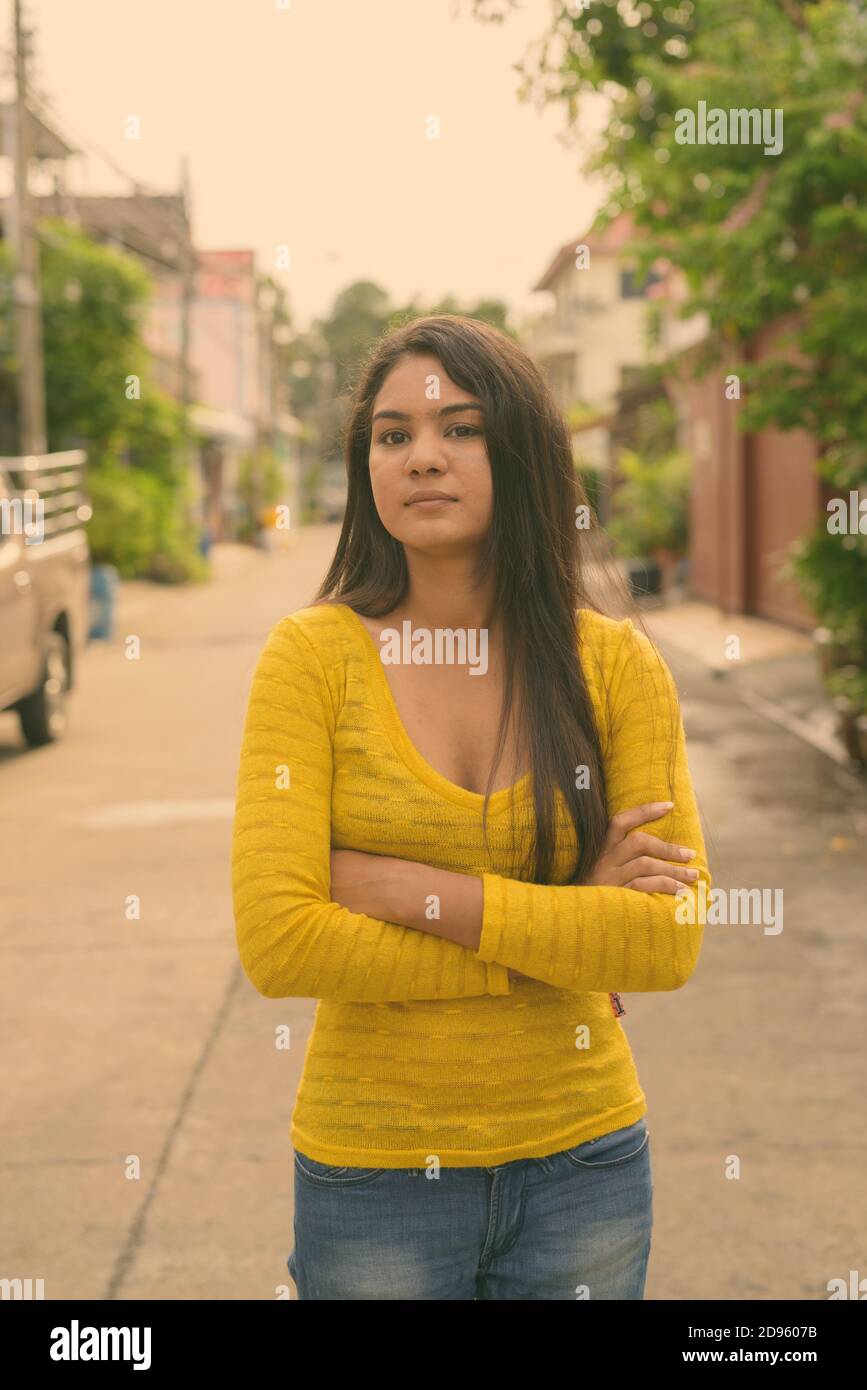 Junge indische Frau mit Waffen in den Straßen überquert im Freien Stockfoto