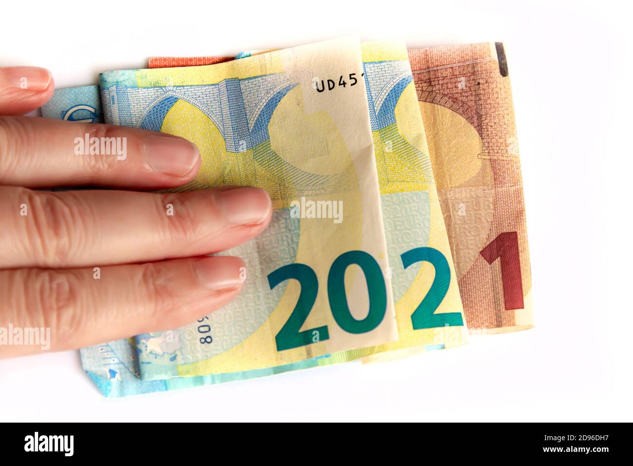 2021 geschrieben mit Euro Banknoten in einer Hand isoliert auf weißem Hintergrund, Neujahrs Grüße Geld Konzept Stockfoto