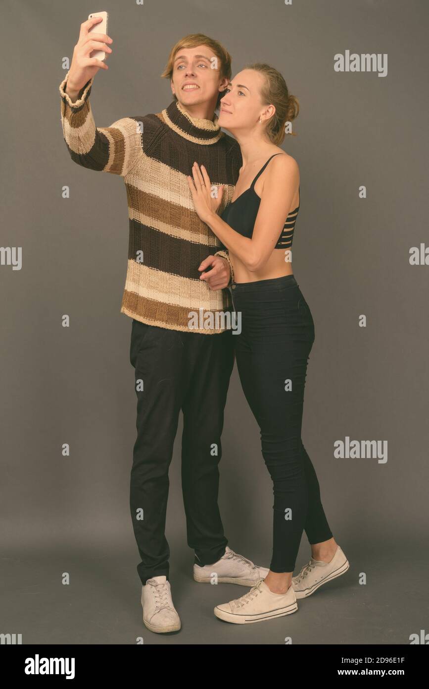 Studio Aufnahme des jungen Paares gemeinsam gegen grauer Hintergrund Stockfoto