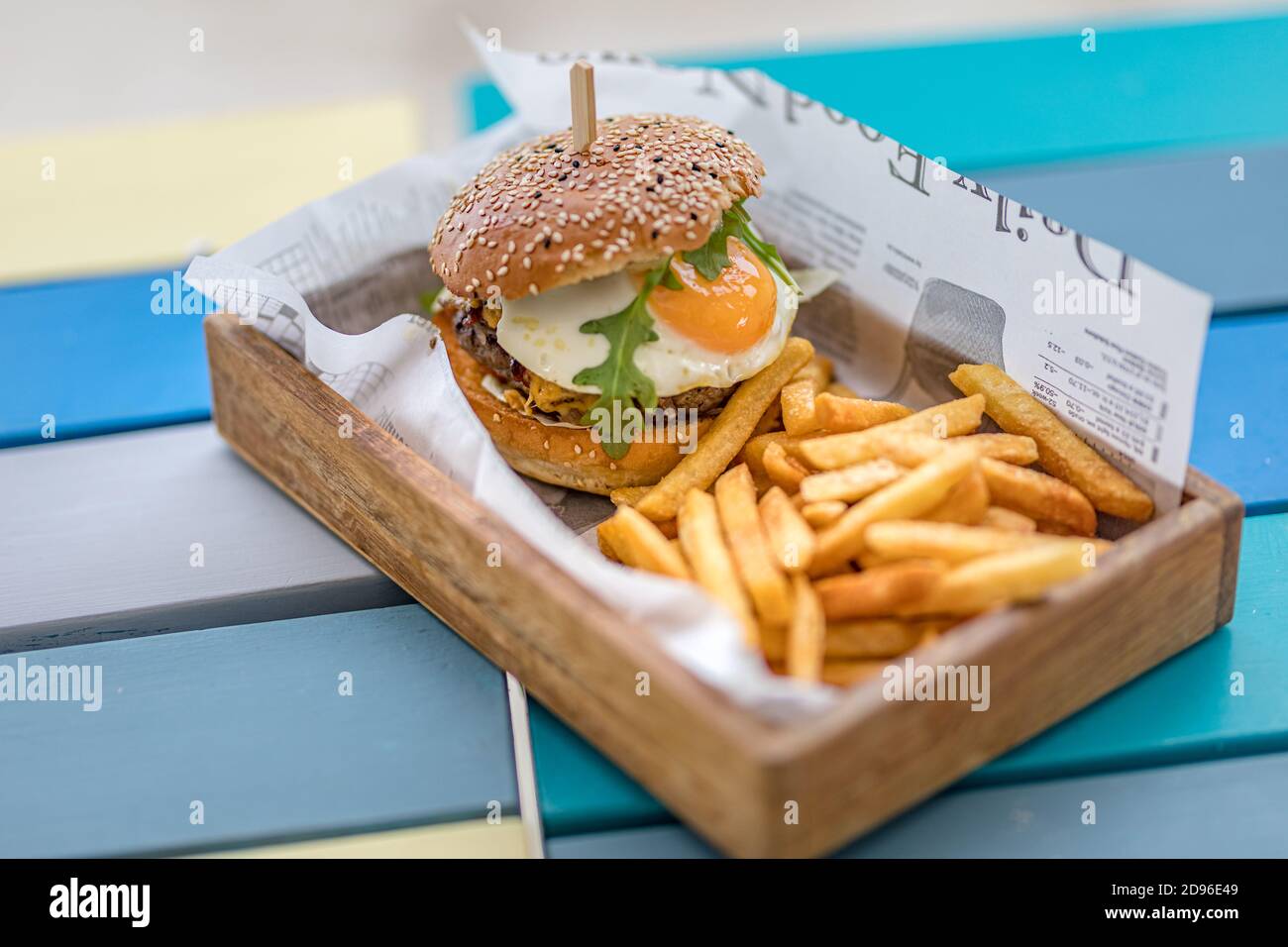 Nahaufnahme von Rindfleisch Burger auf Holztisch Hintergrund. Hamburger gegrillter Fleischburger, Salat, Tomaten und Spiegelei. Handgemachter Gourmet-Burger Stockfoto