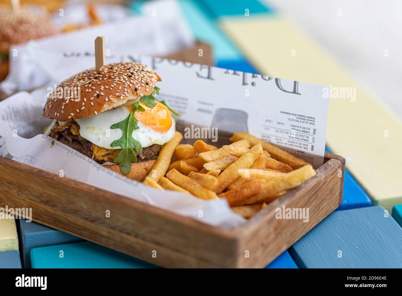 Nahaufnahme von Rindfleisch Burger auf Holztisch Hintergrund. Hamburger gegrillter Fleischburger, Salat, Tomaten und Spiegelei. Handgemachter Gourmet-Burger Stockfoto