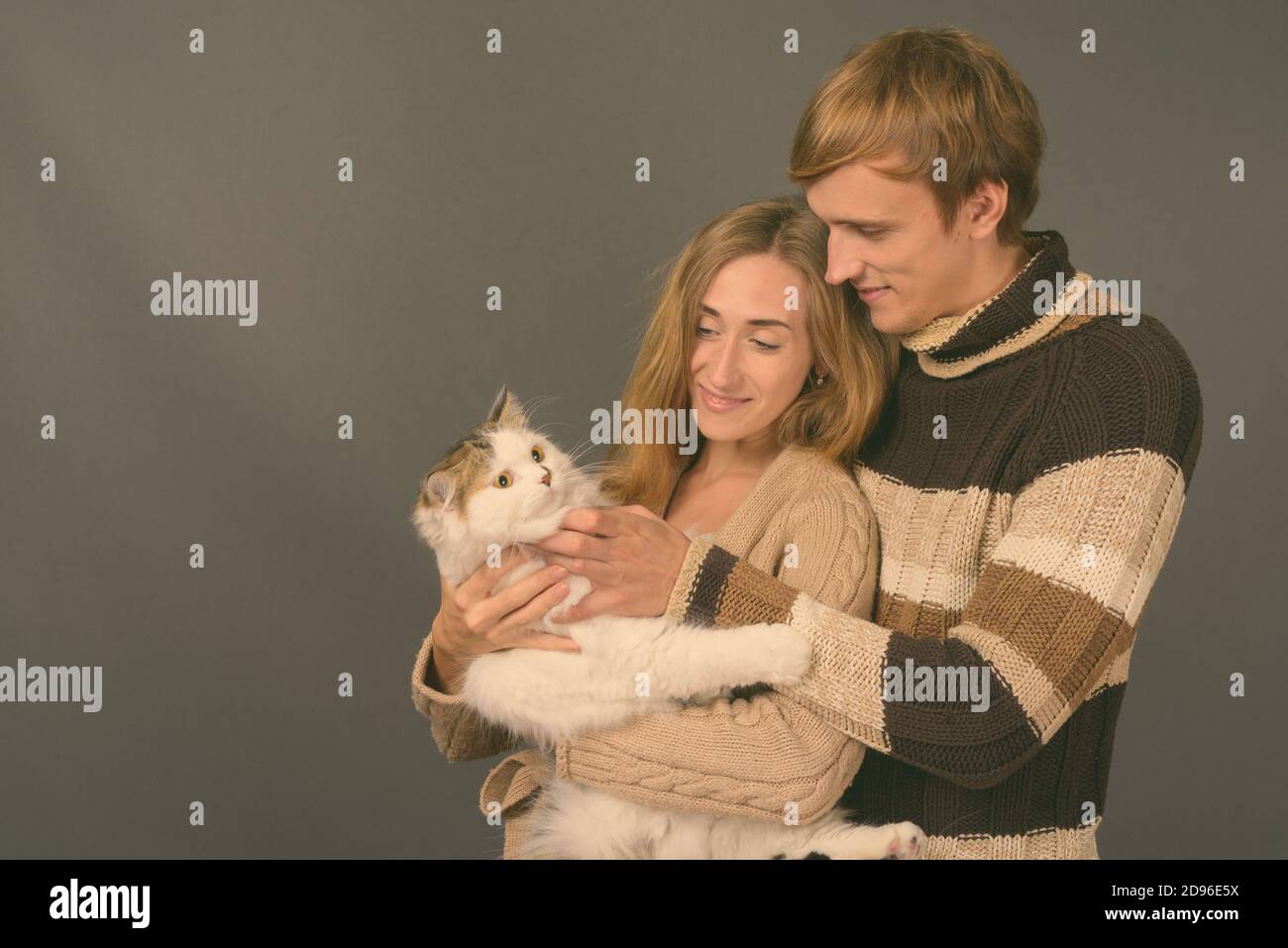 Studio Aufnahme des jungen Paares gemeinsam gegen grauer Hintergrund Stockfoto