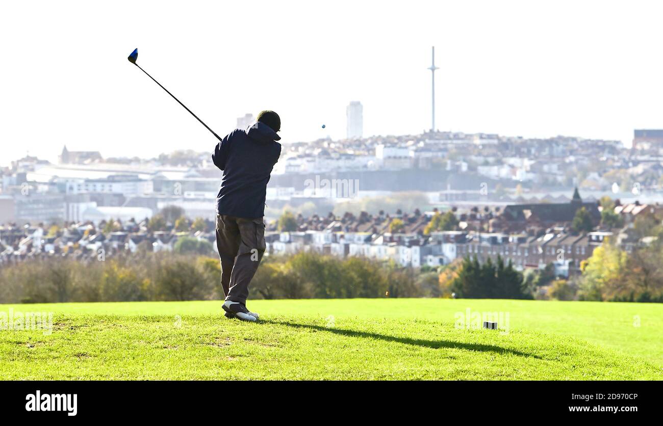 Brighton UK 3. November 2020 - EIN Golfer Abschläge am Hollingbury Park Golfplatz mit Blick auf die Stadt Brighton, bevor die Kurse haben, um in England am Donnerstag wegen der neuen Regierung Lockdown Einschränkungen kommen in am Donnerstag schließen : Credit Simon Dack / Alamy Live News Stockfoto