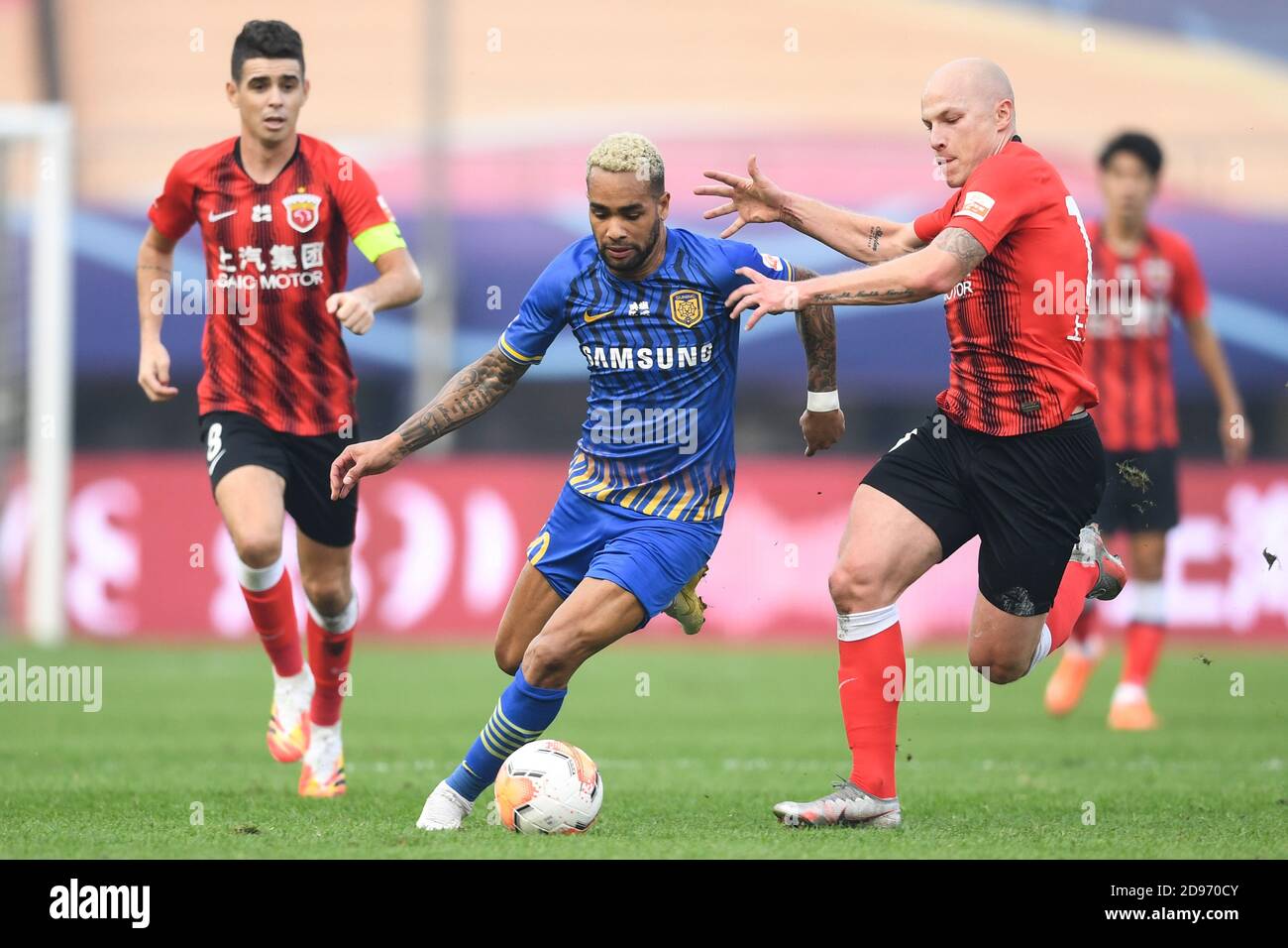 Brasilianischer Fußballspieler Alex Teixeira aus Jiangsu Suning F.C., Mitte, schützt den Ball vor australischem Profifußballspieler Aaron Mooy aus Shanghai SIPG F.C., rechts, während der zweiten Runde des Viertelfinalspiels der 2020 Chinese Super League (CSL), Stadt Suzhou, ostchinesische Provinz Jiangsu, 2. November 2020. Shanghai SIPG F.C. wurde von Jiangsu Suning F.C. mit 1:2 besiegt. Stockfoto