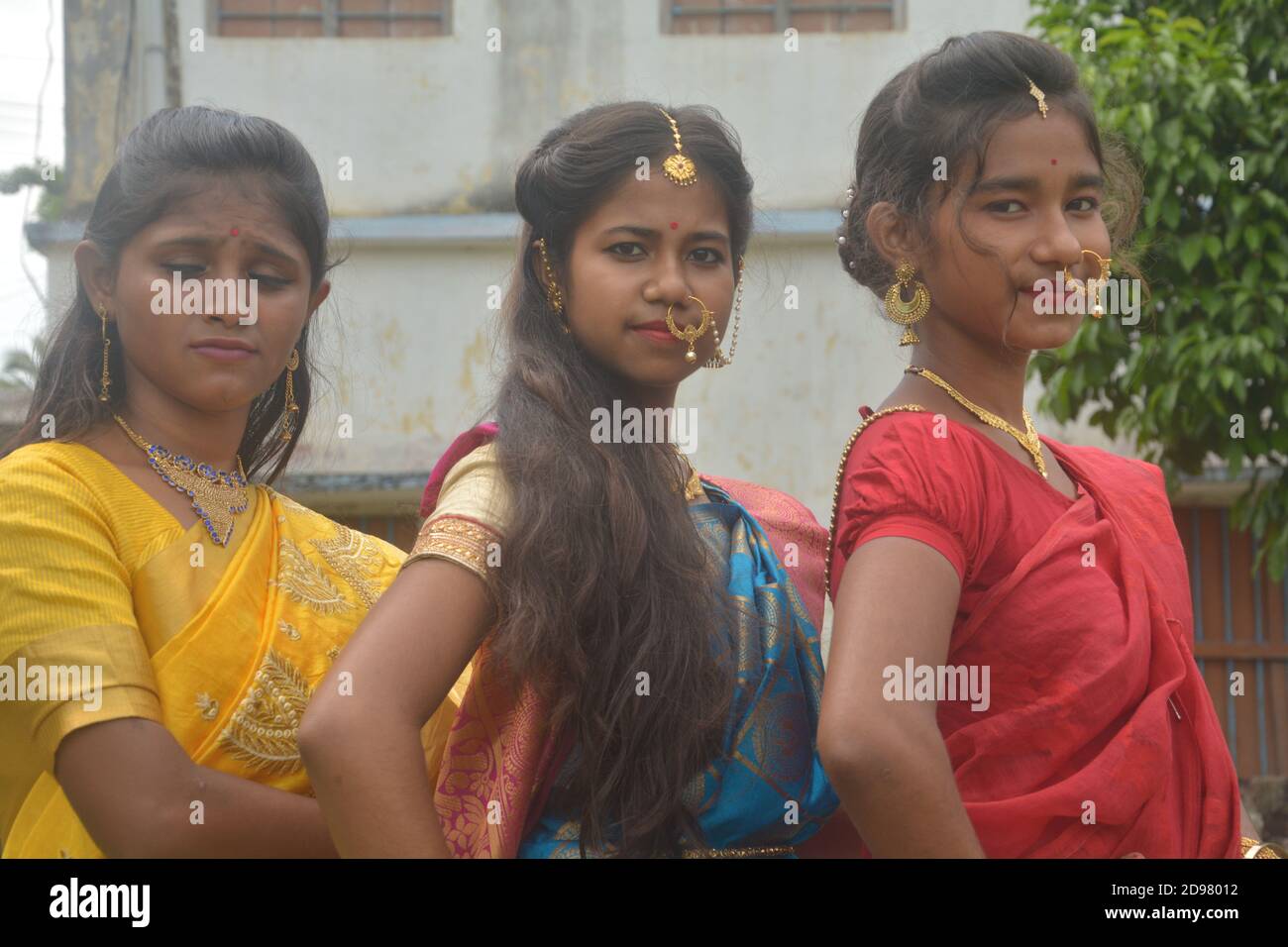 Drei Teenager Bengali Mädchen tragen Saree und Schmuck wie Nasenringe Ohrringe Halskette maang tika mit langen schwarzen Haaren, selektive Fokussierung Stockfoto