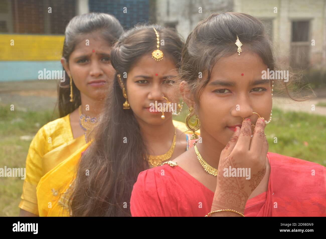 Nahaufnahme von drei Teenager-Mädchen in Indien tragen Sari goldenen Nasenring Maang Tikka Halskette Ohrringe mit Make-up, selektive Fokussierung Stockfoto