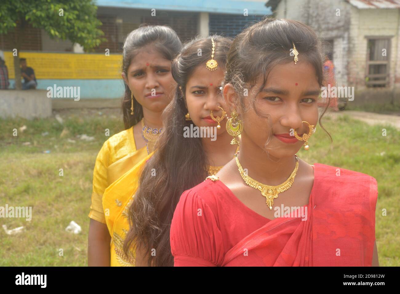 Nahaufnahme von drei Teenager-Mädchen in Indien tragen Sari goldenen Nasenring Maang Tikka Halskette Ohrringe mit Make-up, selektive Fokussierung Stockfoto