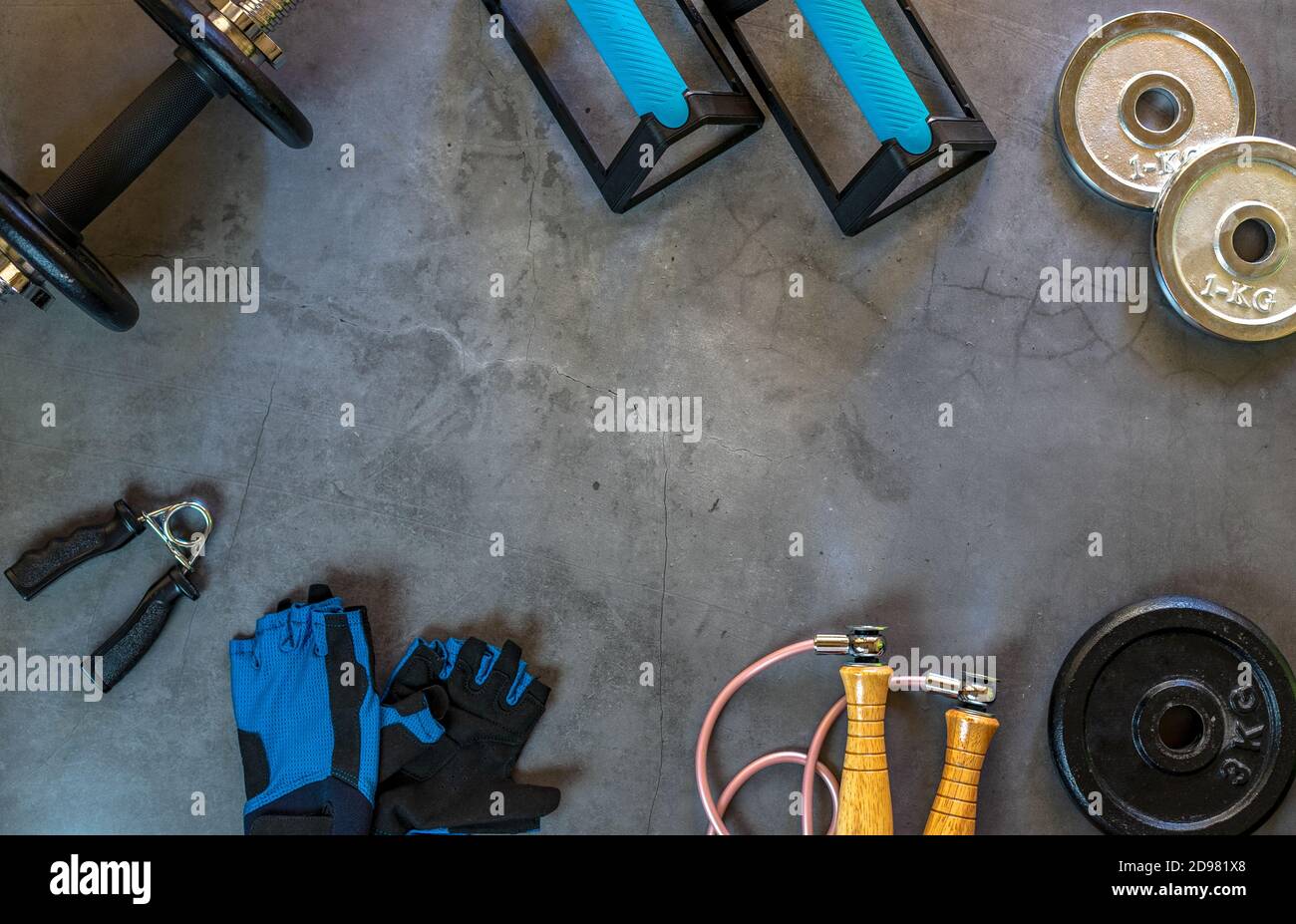 Hintergrund mit Gegenständen für das Training zu Hause. Push-up Bars, Hanteln, Hantelscheiben in verschiedenen Größen, Springseil, Trainingshandschuhe und Handgriff. Stockfoto