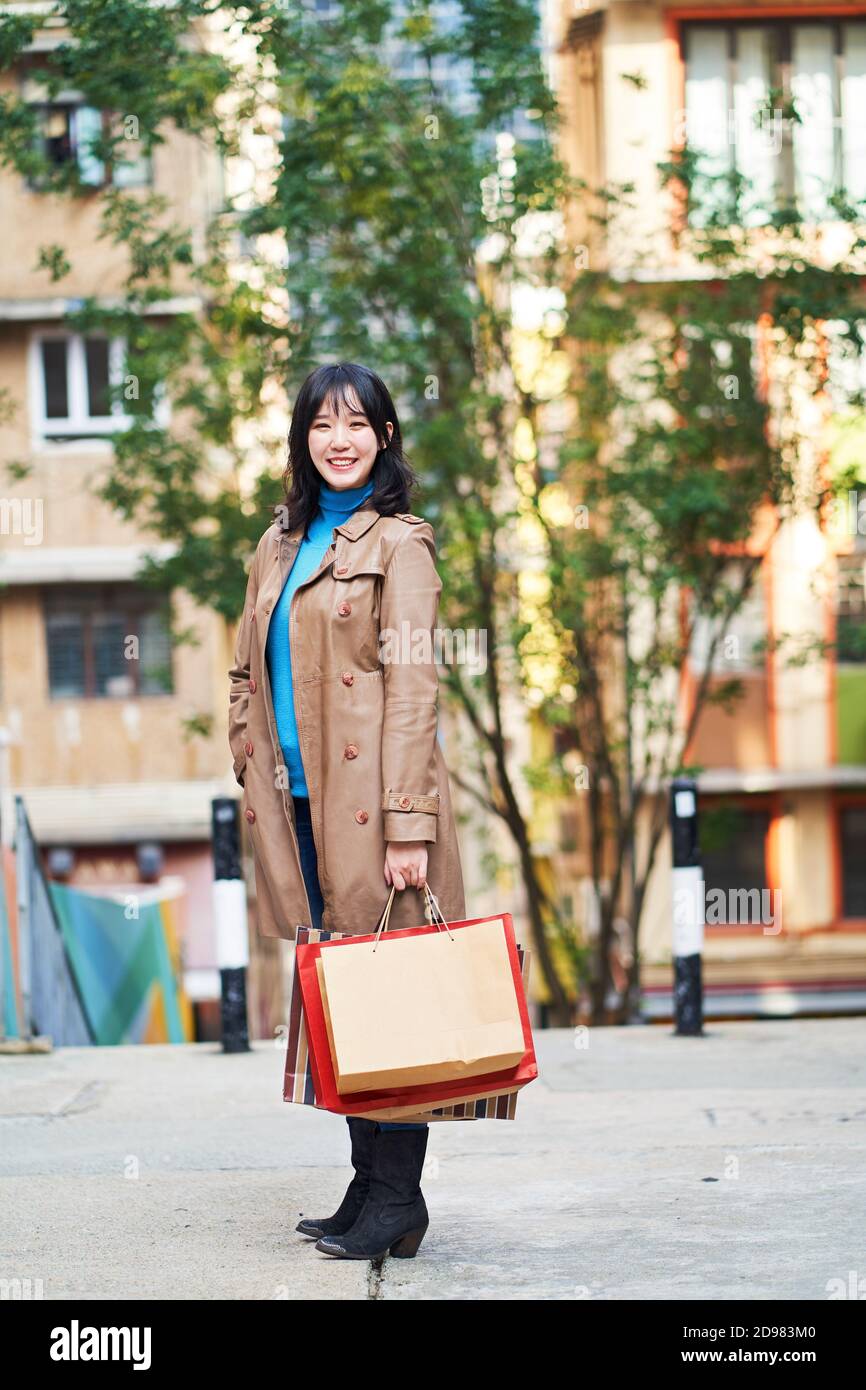 Außenportrait einer jungen asiatischen Frau mit Einkaufstaschen In der Hand Stockfoto