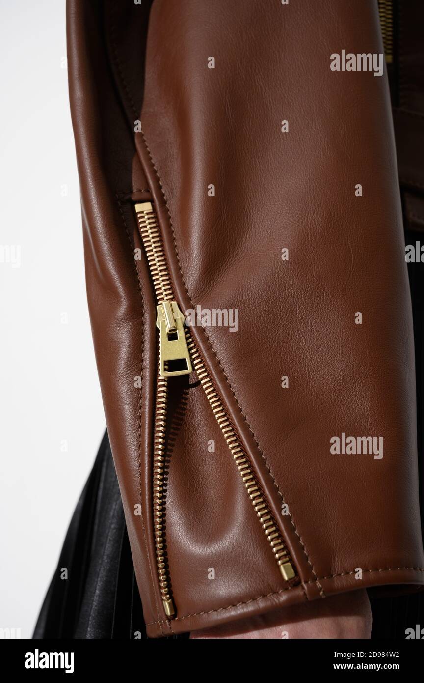 Braune Lederjacke mit Metallreißverschluss am Ärmel. Genähtes Leder. Nahaufnahme. Vertikales Foto. Stockfoto