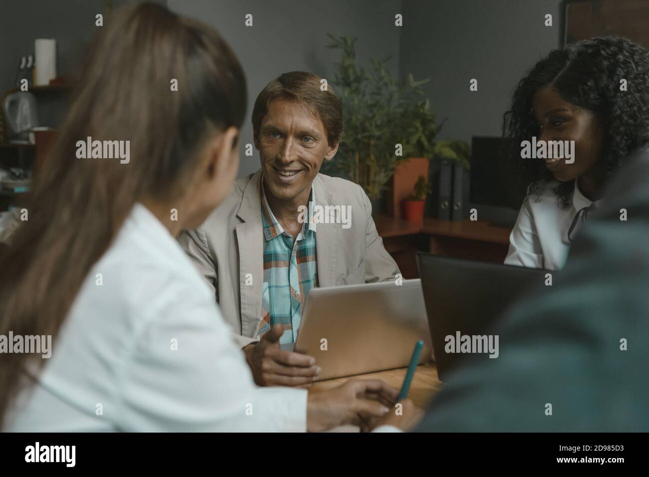 Lustige Geschäftstreffen im Büro. Verschiedene Gruppen von Geschäftsleuten arbeiten zusammen an Projekten Stockfoto