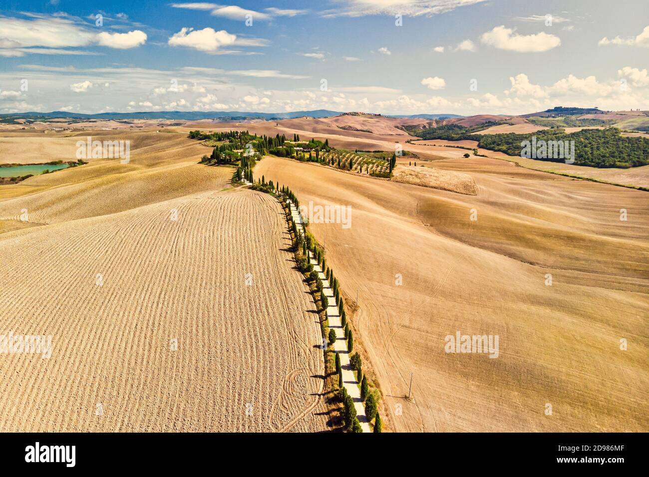 Goldenes Feld der Toskana Italien. Straße mit toskanischen Zypressen gesäumt. Luftaufnahme. Stockfoto