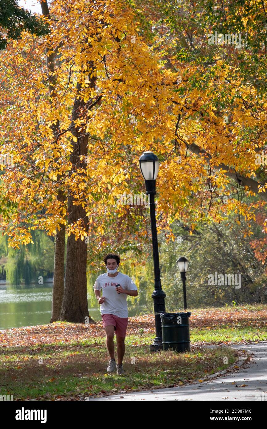 Ein Läufer joggt durch den Kissena Park inmitten der wunderschönen Herbstfarben. In Flushing, Queens, New York City. Stockfoto