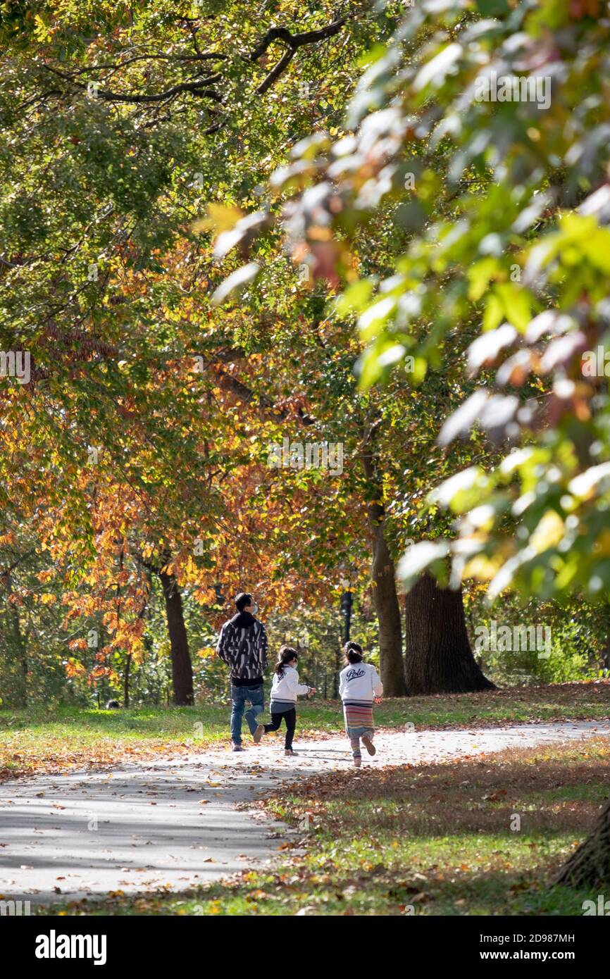 Eine Familie spaziert durch den Kissena Park inmitten der wunderschönen Herbstfarben. In Flushing, Queens, New York City. Stockfoto