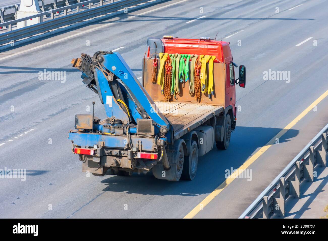 Der kleine LKW-Kran transportiert Ladung auf der Autobahn Stockfoto