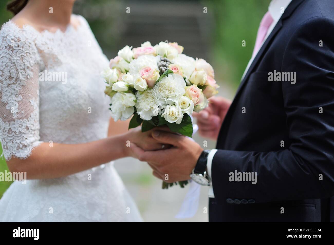 Bräutigam gibt der Braut close-up schöne Hochzeit Bouquet. Für einen Spaziergang im Park Stockfoto