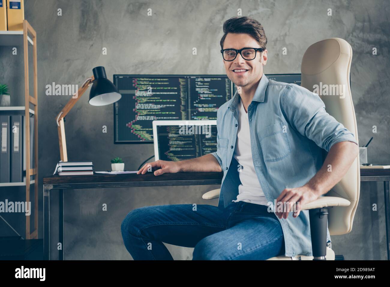 Portrait von positiven Kerl IT-Spezialist sitzen Stuhl Schreibtisch genießen Arbeiten pc Hause bereit Debuggen java-Skript Cyber-Raum Fehler Tragen Sie Jeans Hemd in Stockfoto