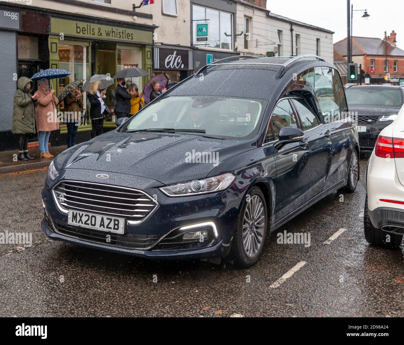 Freunde, Familie und lokale Händler säumen die Straßen, um dem Leichenschauhaus eines lokalen Händlers ihren Respekt zu zollen Stockfoto