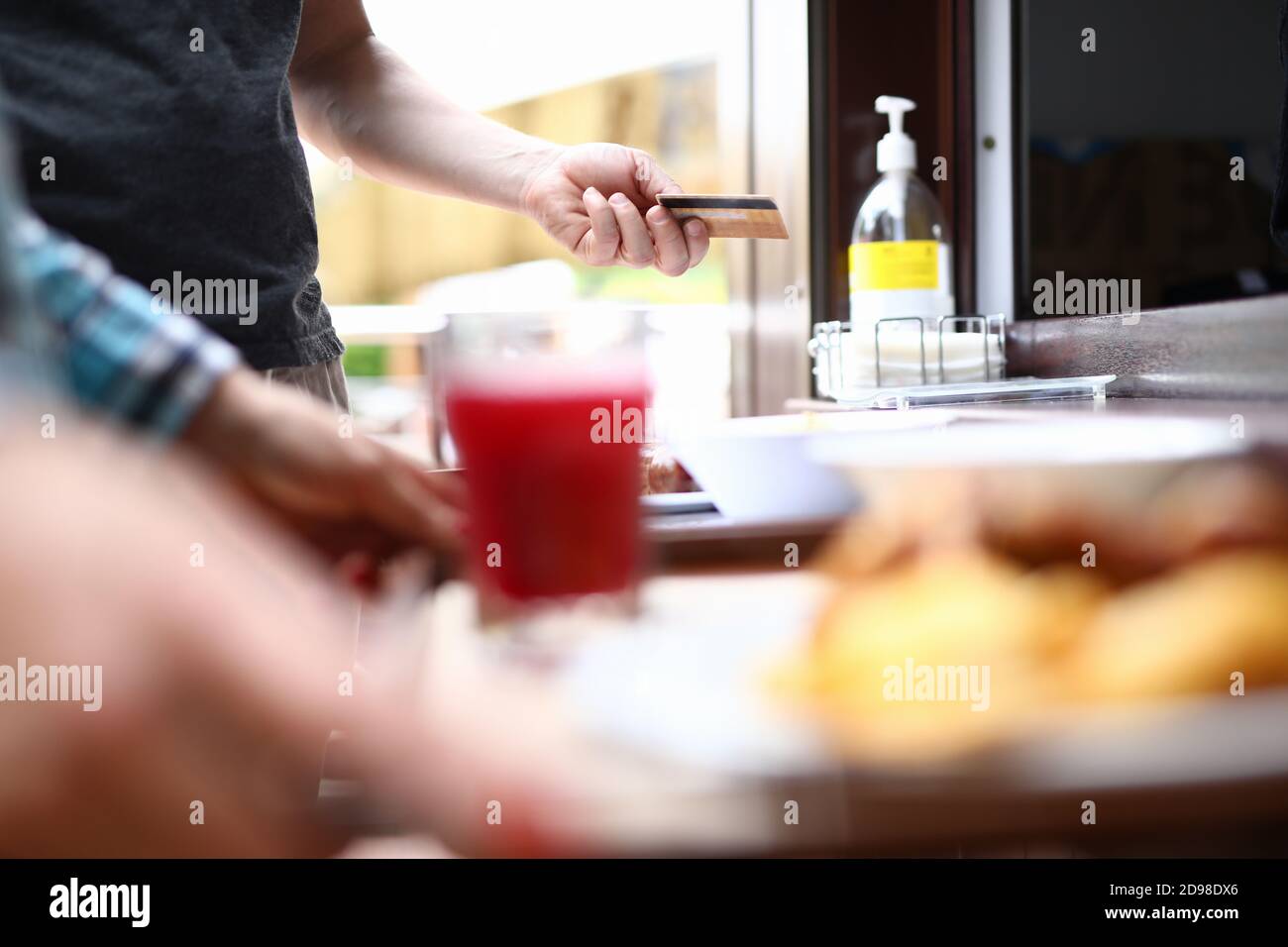 Hand des Mannes hält Bank Plastikkarte auf Hintergrund der Nahrung Stockfoto