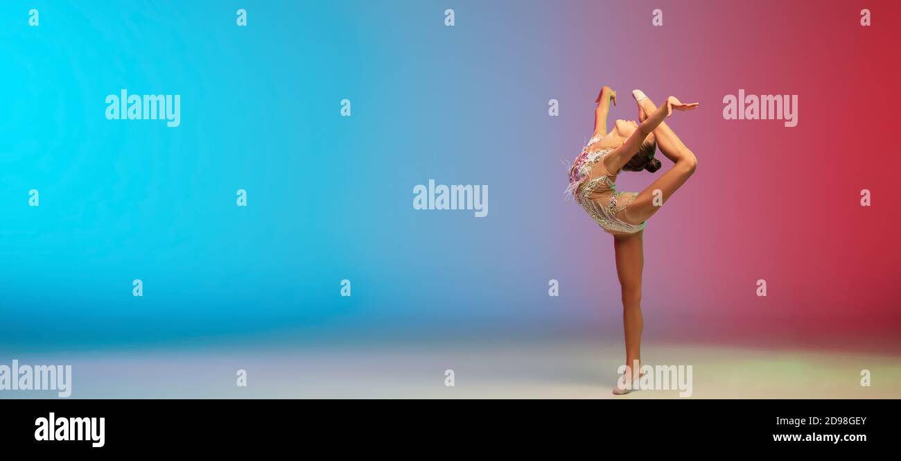 Flyer. Kleine kaukasische Mädchen, rhythmische Turnerausbildung, Durchführung isoliert auf Gradienten blau-roten Studio Hintergrund in Neon. Anmutig und flexibel, starkes Kind. Konzept von Sport, Bewegung, Action. Stockfoto