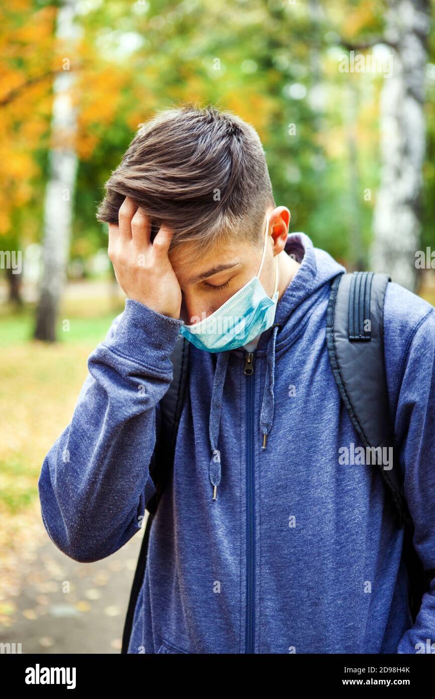 Kranker junger Mann in der Grippe-Maske im Herbst Parken Stockfoto