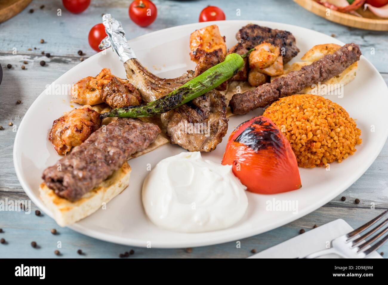 Gemischter Grill auf Holztisch. Lammkoteletts, Adana Kebab, Hühnerfleisch, Schischbällchen, Steak. Stockfoto