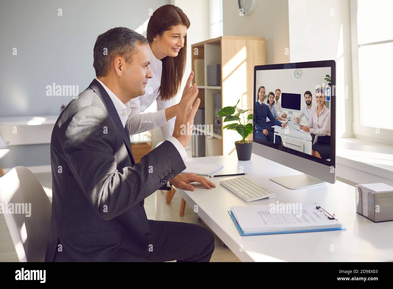 Teams zufriedener Mitarbeiter aus verschiedenen Abteilungen mit Video Konferenz Stockfoto