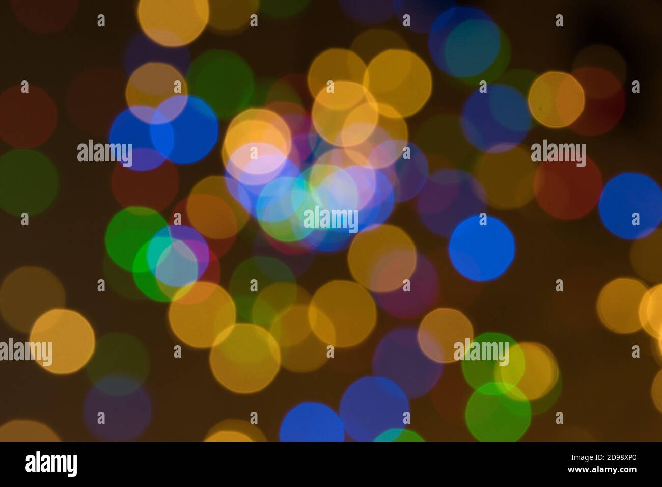 Abstrakter unscharfer Hintergrund mit bunten orangefarbenen, blaugrünen und roten Bokeh-Kugeln auf dunklem Hintergrund Stockfoto