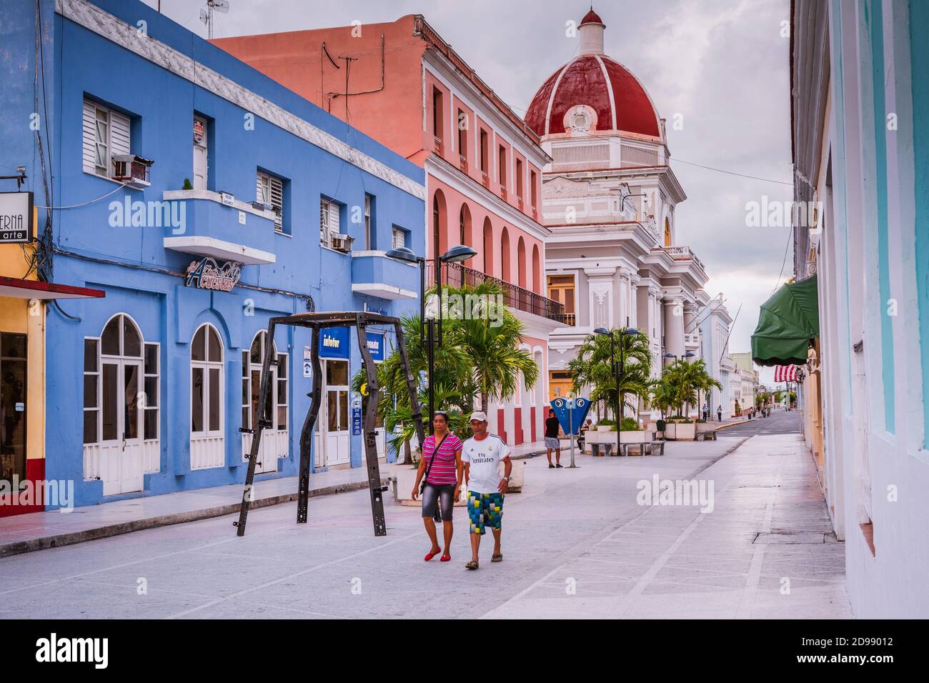 Ein Paar zu Fuß, trägt er ein T-Shirt von Real Madrid C.F.. Boulevard San Fernando, Fußgängerzone, im Hintergrund der Regierungspalast Cienfuegos, Stockfoto