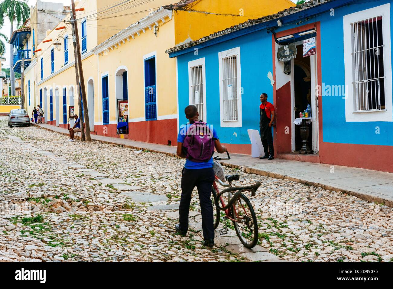 Ein Mann mit dem Fahrrad geht durch das historische Zentrum von Trinidad, Sancti Spíritus, Kuba, Lateinamerika und der Karibik Stockfoto