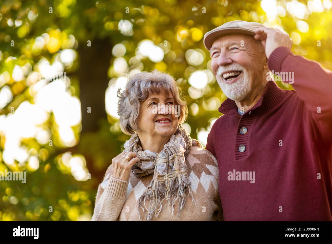 Glückliches Seniorenpaar, das Zeit zusammen in einem wunderschönen Stadtpark verbringt Im Herbst Stockfoto