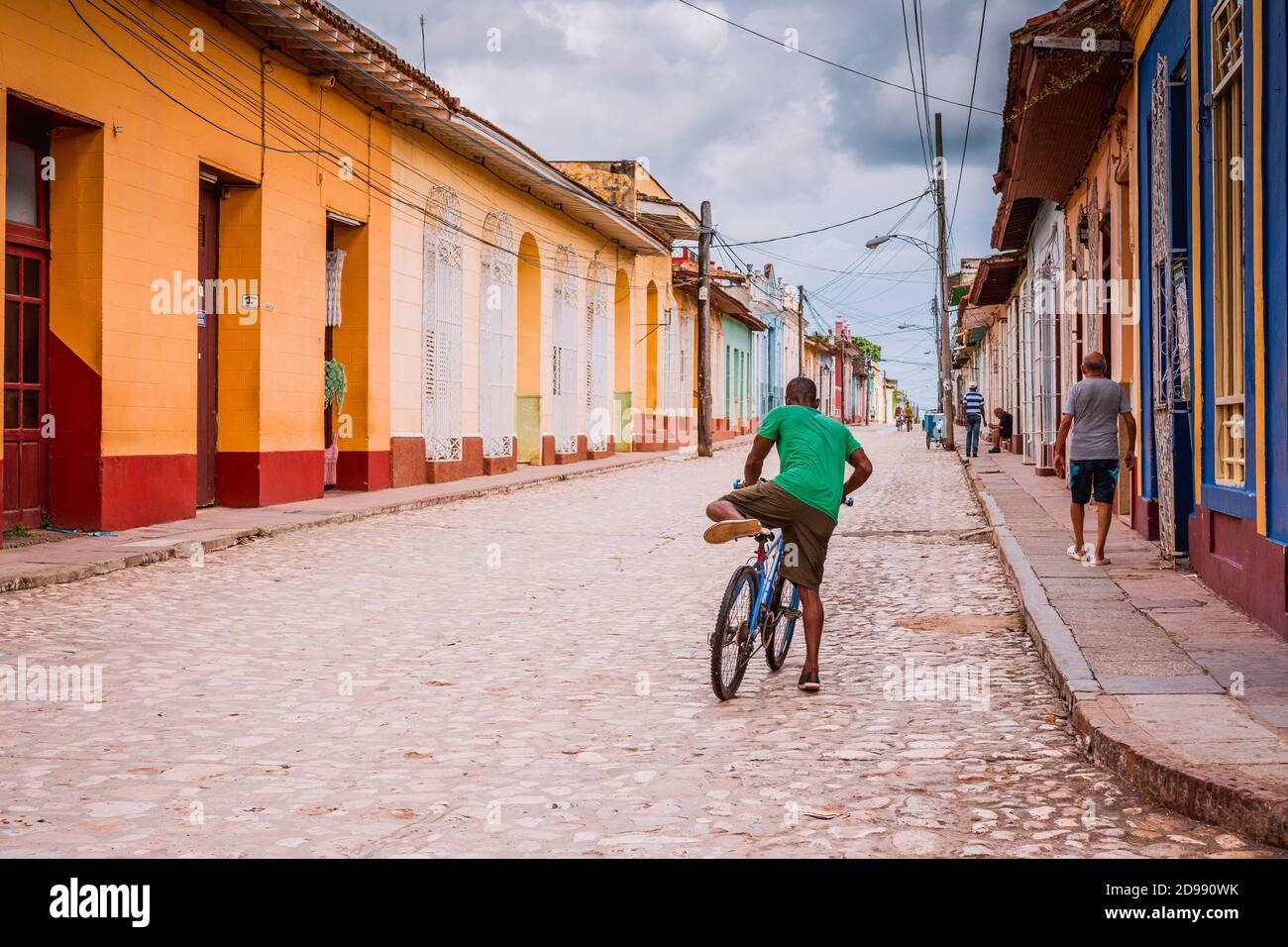 Ein Mann mit dem Fahrrad geht durch das historische Zentrum von Trinidad, Sancti Spíritus, Kuba, Lateinamerika und der Karibik Stockfoto
