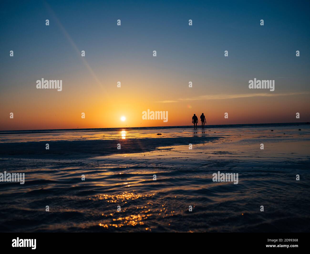 Ein paar Spaziergänge während des Sonnenuntergangs auf dem flachen Wasser der Isla Holbox, Mexiko am Samstag, 5. Mai 2018. Stockfoto