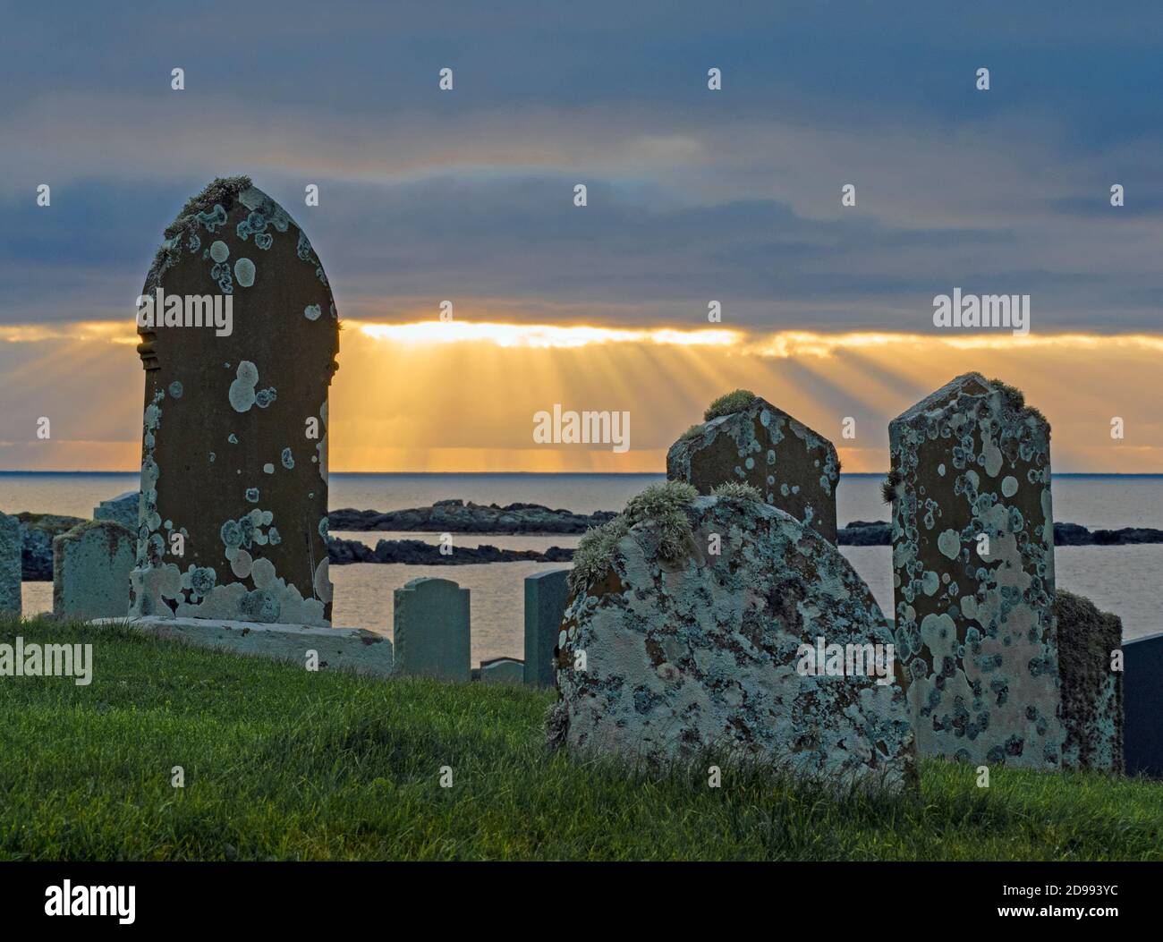 Blick auf Grabsteine auf dem Friedhof mit Sonnenstrahlen am Morgen hinter, in der Nähe von Mail, Festland Shetland, Schottland Stockfoto