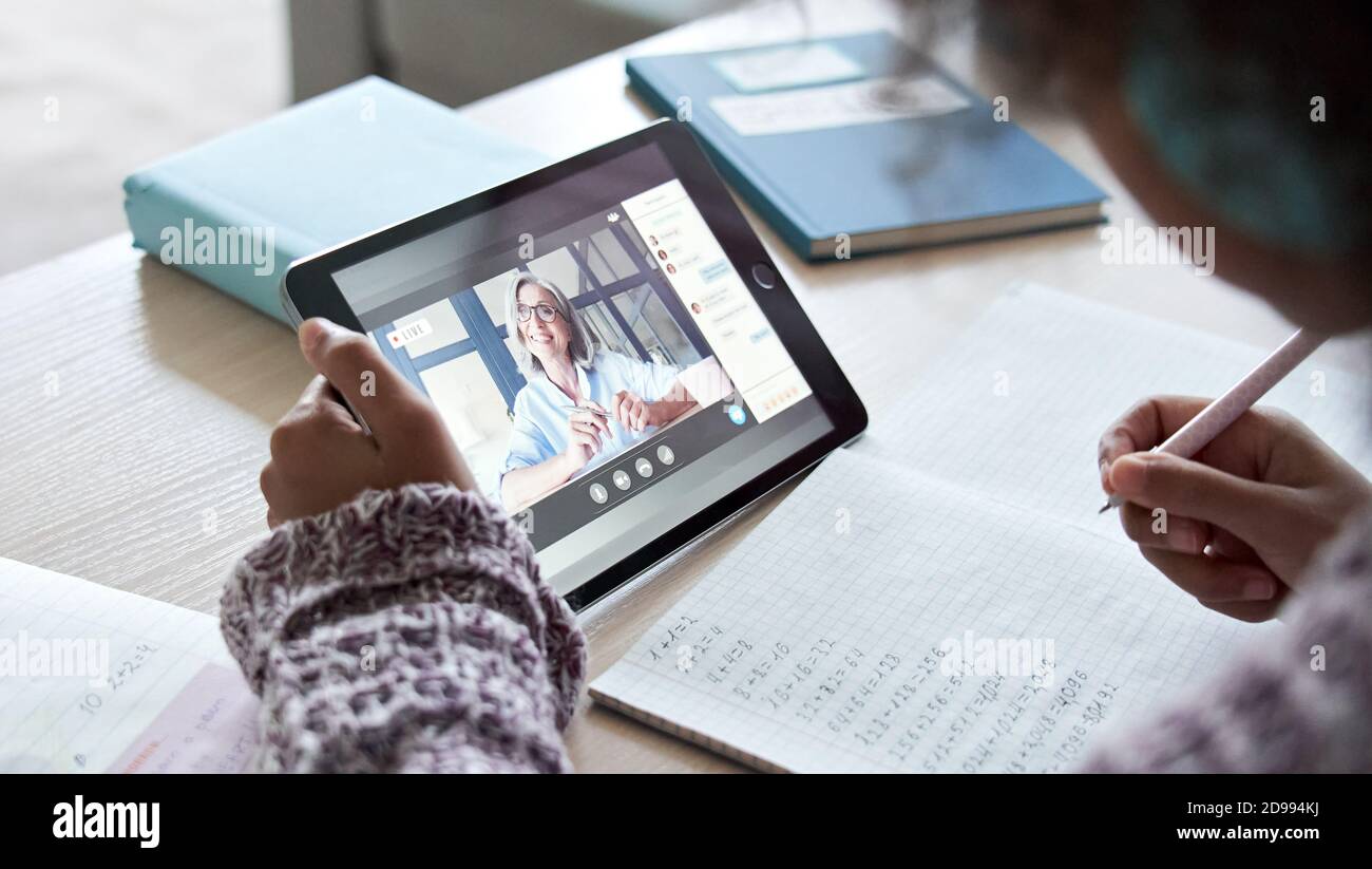 Afrikanisches Kind Mädchen hält Tablet im Gespräch mit Lehrer auf Distanz Videoanruf. Stockfoto