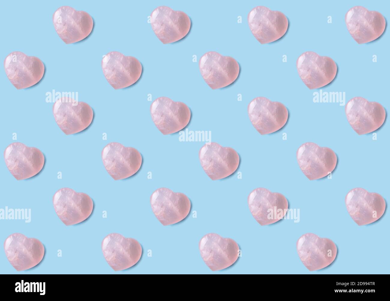 Rose Quarts Kristall Herzen Tapete Hintergrund. Rosa 3D Herzen auf hellblauem Hintergrund. Stockfoto