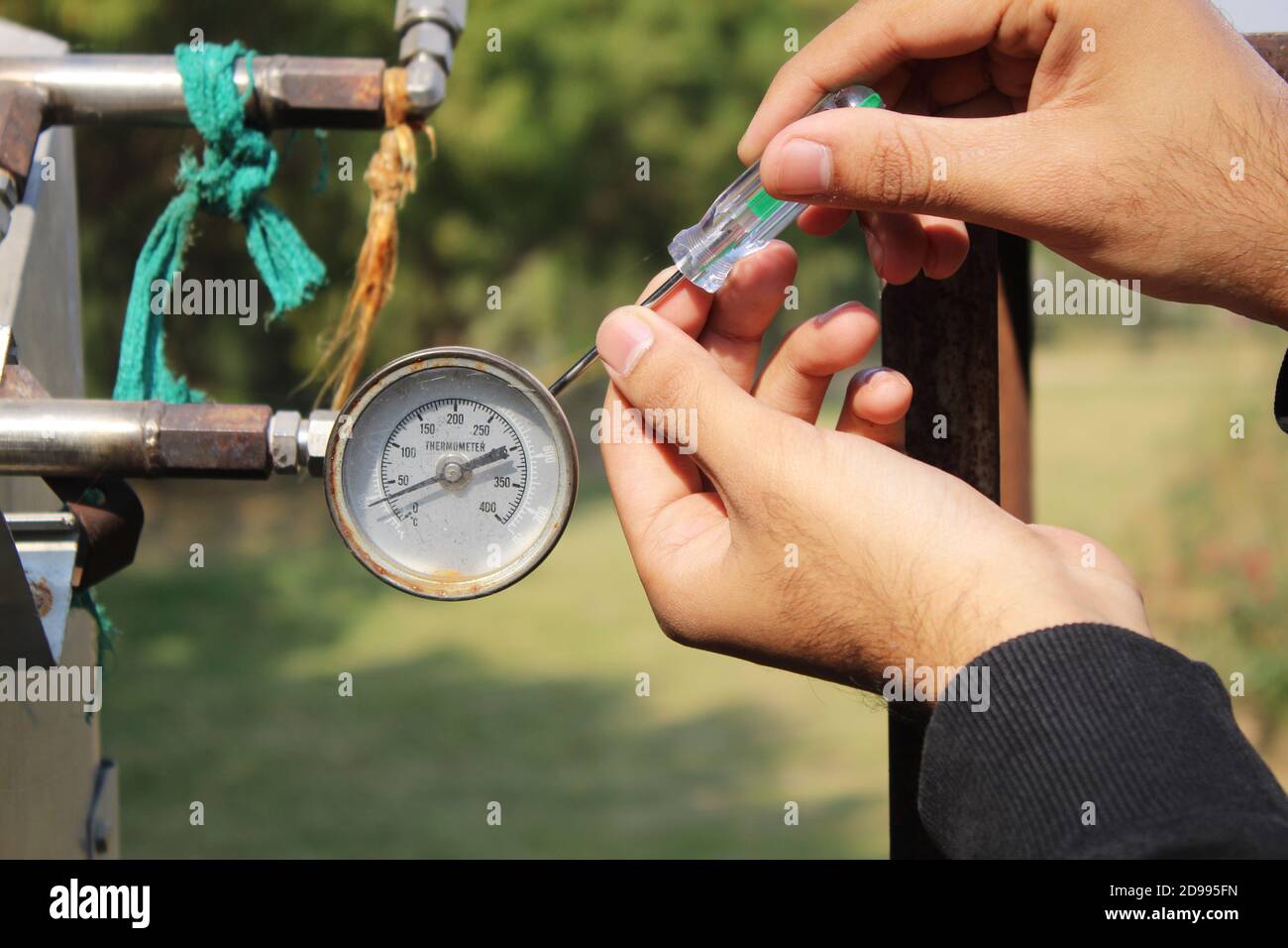 Nahaufnahme der Hand des Arbeiters, der das Temperaturmessgerät von fixiert Solarheizung Stockfoto