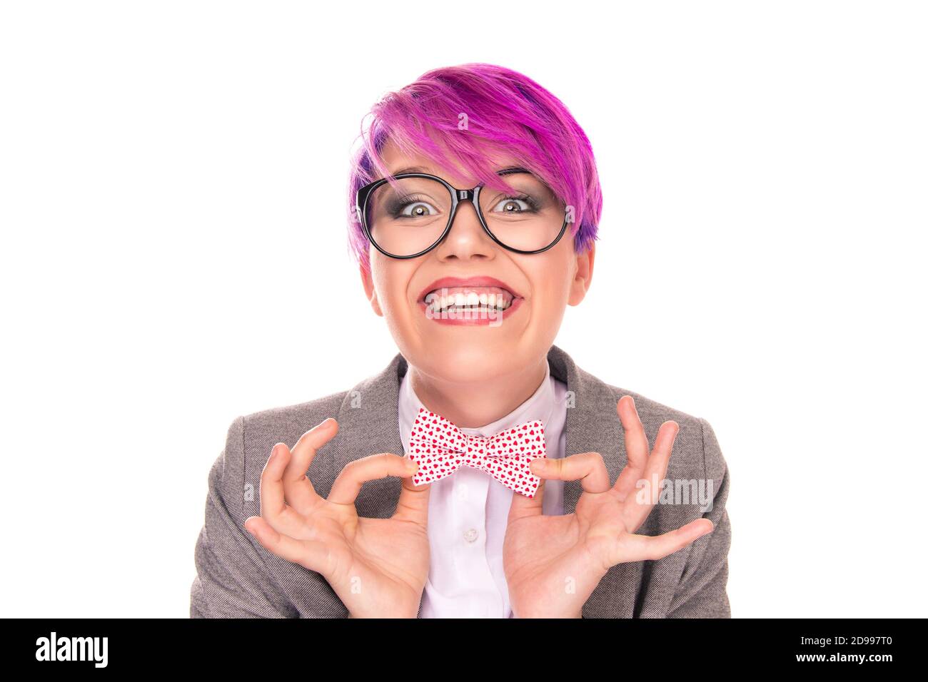 Aufgeregt Nerd. Portrait von lustigen jungen Mädchen Frau mit magenta lila rosa Haar halten Fliege mit Fingern zeigt es auf Sie Kamera lachend Stockfoto